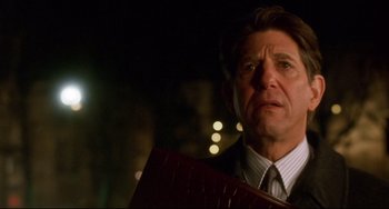 Movie still from “Femme Fatale” (2002), directed by Brian De Palma – A person wearing a suit and tie; Close Up shot, Low angle