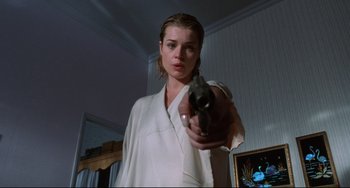 Movie still from “Femme Fatale” (2002), directed by Brian De Palma – A woman holding a gun in a room; Close Up shot, Low angle
