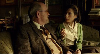 Movie still from “The Shape of Water” (2017), directed by Guillermo del Toro – An older man sitting next to a younger woman on a couch; Medium shot, Over the shoulder angle