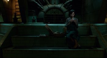 Movie still from “The Shape of Water” (2017), directed by Guillermo del Toro – A woman sitting on the steps looking at her cell phone; Wide shot, High angle