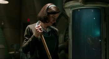 Movie still from “The Shape of Water” (2017), directed by Guillermo del Toro – A woman holding a wooden stick in a room; Medium shot, Low angle