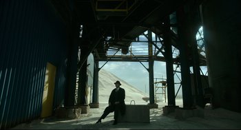 Movie still from “The Shape of Water” (2017), directed by Guillermo del Toro – A man in a suit and tie sitting on a bench; Wide shot, Low angle