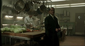 Movie still from “The Shape of Water” (2017), directed by Guillermo del Toro – A man standing in front of a table in a kitchen; Medium shot, Low angle