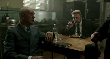 Movie still from “The Shape of Water” (2017), directed by Guillermo del Toro – Two men sitting at a table eating food and drinking wine; Medium shot, Over the shoulder angle