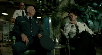 Movie still from “The Shape of Water” (2017), directed by Guillermo del Toro – A group of men sitting next to each other in a room; Medium shot, Low angle