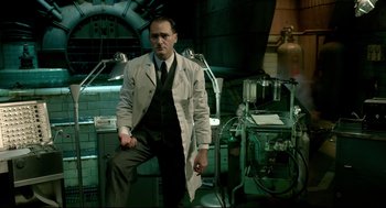 Movie still from “The Shape of Water” (2017), directed by Guillermo del Toro – A man in a white lab coat standing in front of a machine; Medium shot, Low angle
