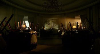 Movie still from “The Shape of Water” (2017), directed by Guillermo del Toro – A room filled with chairs and a painting on the wall; Wide shot, Low angle