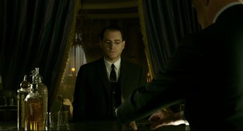 Movie still from “The Shape of Water” (2017), directed by Guillermo del Toro – A man in a suit and tie standing in front of a mirror; Medium shot, Low angle