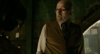 Movie still from “The Shape of Water” (2017), directed by Guillermo del Toro – An older man wearing glasses and a vest; Medium shot, Over the shoulder angle