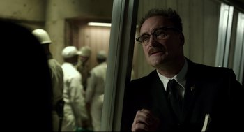 Movie still from “The Shape of Water” (2017), directed by Guillermo del Toro – A man in a suit and tie standing in front of a mirror; Close Up shot, Low angle