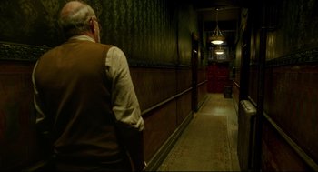 Movie still from “The Shape of Water” (2017), directed by Guillermo del Toro – An older man walking down a hallway in a building; Wide shot, High angle