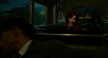 Movie still from “The Shape of Water” (2017), directed by Guillermo del Toro – A woman sitting on a bus looking into a mirror; Medium shot, Over the shoulder angle