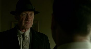 Movie still from “The Shape of Water” (2017), directed by Guillermo del Toro – An older man wearing a suit and hat; Close Up shot, Over the shoulder angle