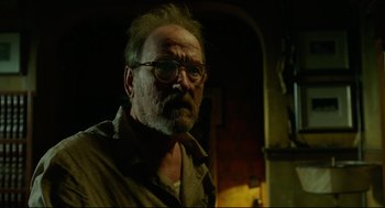 Movie still from “The Shape of Water” (2017), directed by Guillermo del Toro – An older man with a beard wearing glasses and a brown shirt; Close Up shot, Low angle