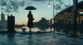 Movie still from “The Shape of Water” (2017), directed by Guillermo del Toro – A woman holding an umbrella while standing in the rain; Extreme Wide shot, Low angle