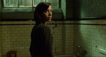 Movie still from “The Shape of Water” (2017), directed by Guillermo del Toro – A person standing in a room with a window in the background; Medium shot, Low angle