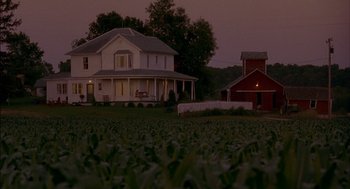 Movie still from “Field of Dreams” (1989), directed by Phil Alden Robinson – A large white house sitting on top of a lush green field; Extreme Wide shot, High angle