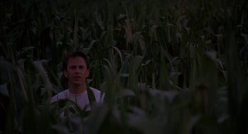 Movie still from “Field of Dreams” (1989), directed by Phil Alden Robinson – A man standing in the middle of a corn field at night; Medium shot, Over the shoulder angle