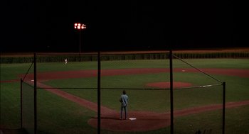 Movie still from “Field of Dreams” (1989), directed by Phil Alden Robinson – A man standing on a baseball field at night; Extreme Wide shot, High angle
