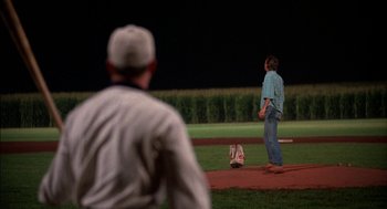 Movie still from “Field of Dreams” (1989), directed by Phil Alden Robinson – Two men are playing baseball on a field; Wide shot, Over the shoulder angle