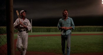 Movie still from “Field of Dreams” (1989), directed by Phil Alden Robinson – Two men standing on a baseball field at night; Wide shot, Low angle