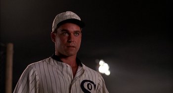 Movie still from “Field of Dreams” (1989), directed by Phil Alden Robinson – A man in a baseball uniform standing in the dark; Close Up shot, Low angle