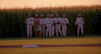 Movie still from “Field of Dreams” (1989), directed by Phil Alden Robinson – A group of baseball players standing next to a field; Wide shot, Over the shoulder angle