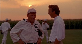 Movie still from “Field of Dreams” (1989), directed by Phil Alden Robinson – Two baseball players talking to each other in a field; Medium shot, Over the shoulder angle
