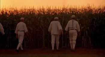 Movie still from “Field of Dreams” (1989), directed by Phil Alden Robinson – A group of men walking through a corn field at sunset; Wide shot, Low angle
