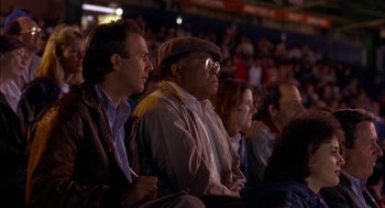 Movie still from “Field of Dreams” (1989), directed by Phil Alden Robinson – A group of people sitting in a crowd at a sporting event; Medium shot, Low angle