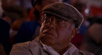 Movie still from “Field of Dreams” (1989), directed by Phil Alden Robinson – An older man wearing glasses and a hat; Close Up shot, Low angle
