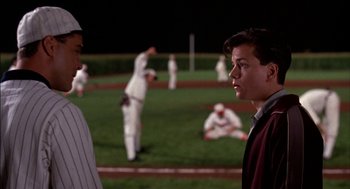 Movie still from “Field of Dreams” (1989), directed by Phil Alden Robinson – Two baseball players are standing on a field; Medium shot, Over the shoulder angle