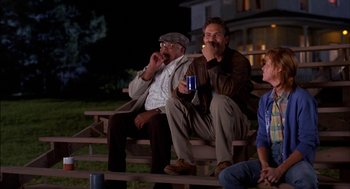 Movie still from “Field of Dreams” (1989), directed by Phil Alden Robinson – A group of men sitting on top of a wooden bench; Medium shot, Over the shoulder angle