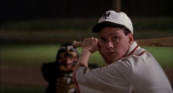 Movie still from “Field of Dreams” (1989), directed by Phil Alden Robinson – A man holding a baseball bat while standing next to another man; Close Up shot, Low angle