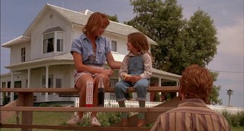 Movie still from “Field of Dreams” (1989), directed by Phil Alden Robinson – A woman sitting on top of a wooden bench next to a child; Medium shot, Over the shoulder angle