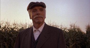 Movie still from “Field of Dreams” (1989), directed by Phil Alden Robinson – An older man wearing a suit and a hat; Close Up shot, Low angle
