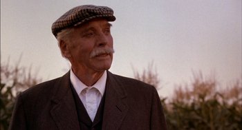 Movie still from “Field of Dreams” (1989), directed by Phil Alden Robinson – An older man wearing a hat and a suit; Close Up shot, Low angle