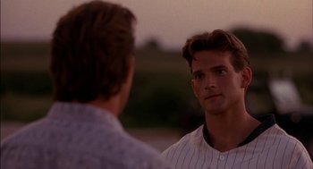 Movie still from “Field of Dreams” (1989), directed by Phil Alden Robinson – A man wearing a baseball uniform talking to another man; Close Up shot, Over the shoulder angle