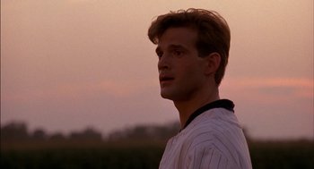 Movie still from “Field of Dreams” (1989), directed by Phil Alden Robinson – A baseball player is looking into the distance at dusk; Close Up shot, Over the shoulder angle