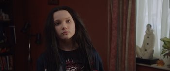 Movie still from “Fighting with My Family” (2019), directed by Stephen Merchant – A girl with long black hair is posing for a picture; Close Up shot, Over the shoulder angle