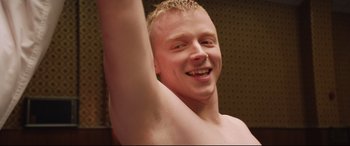 Movie still from “Fighting with My Family” (2019), directed by Stephen Merchant – A young man is smiling while holding his arm up; Close Up shot, Overhead angle