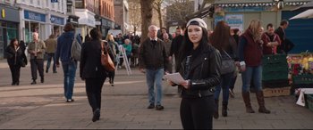 Movie still from “Fighting with My Family” (2019), directed by Stephen Merchant – A woman holding papers while standing on a sidewalk; Medium shot, Over the shoulder angle