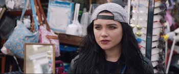 Movie still from “Fighting with My Family” (2019), directed by Stephen Merchant – A woman with long black hair wearing a baseball cap; Close Up shot, Over the shoulder angle