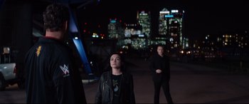 Movie still from “Fighting with My Family” (2019), directed by Stephen Merchant – A woman and a man standing in front of a city skyline at night; Wide shot, Over the shoulder angle
