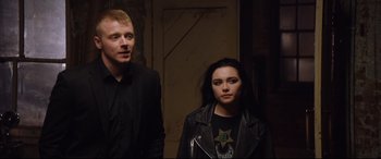 Movie still from “Fighting with My Family” (2019), directed by Stephen Merchant – A man and a woman standing next to each other; Medium shot, Over the shoulder angle