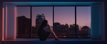 Movie still from “Fighting with My Family” (2019), directed by Stephen Merchant – A woman sitting in front of a window at night; Wide shot, High angle