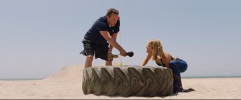 Movie still from “Fighting with My Family” (2019), directed by Stephen Merchant – A man and a woman playing a game on a beach; Wide shot, Low angle