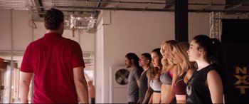 Movie still from “Fighting with My Family” (2019), directed by Stephen Merchant – A group of people standing next to each other in a room; Medium shot, Over the shoulder angle
