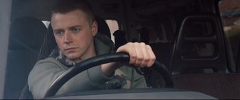 Movie still from “Fighting with My Family” (2019), directed by Stephen Merchant – A young man driving a car in the back of a vehicle; Close Up shot, Low angle