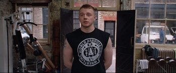Movie still from “Fighting with My Family” (2019), directed by Stephen Merchant – A man in a t - shirt is standing in an alley; Medium shot, Over the shoulder angle